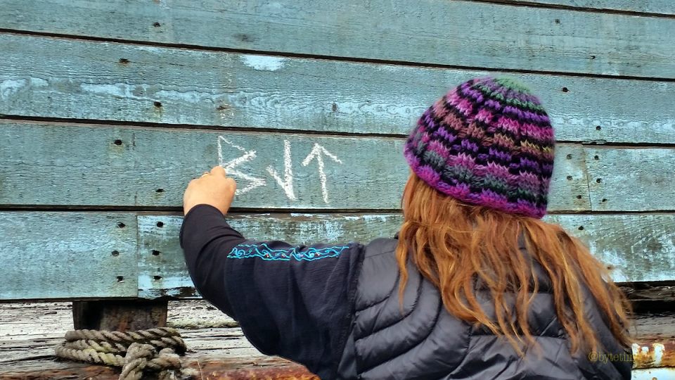 Tracey writing Rune graff with chalk, Faroe Islands